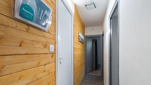 A hallway with wooden paneling on one side, a white door, and a framed picture on the wall.