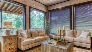 A cozy living room with two beige sofas, a wooden coffee table, and a patterned rug.