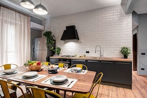 Enjoy meals in this stylish kitchen and dining area, featuring a brick backsplash, range hood, and refrigerator.