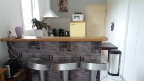 A kitchen with a bar area, a microwave, a coffee maker, and a trash can. - 4-bedroom house in the heart of the Abers (7-minute walk from Ganaoc beach) (Saint-Pabu)