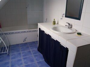 Ein Badezimmer mit Badewanne, Waschbecken und Spiegel.