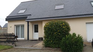 A single-story house with a grey tiled roof, a front door, and a small window. - 4-bedroom house in the heart of the Abers (7-minute walk from Ganaoc beach) (Saint-Pabu)