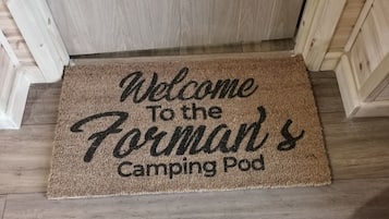 A welcome mat with the text "Welcome To the Forman's Camping Pod".