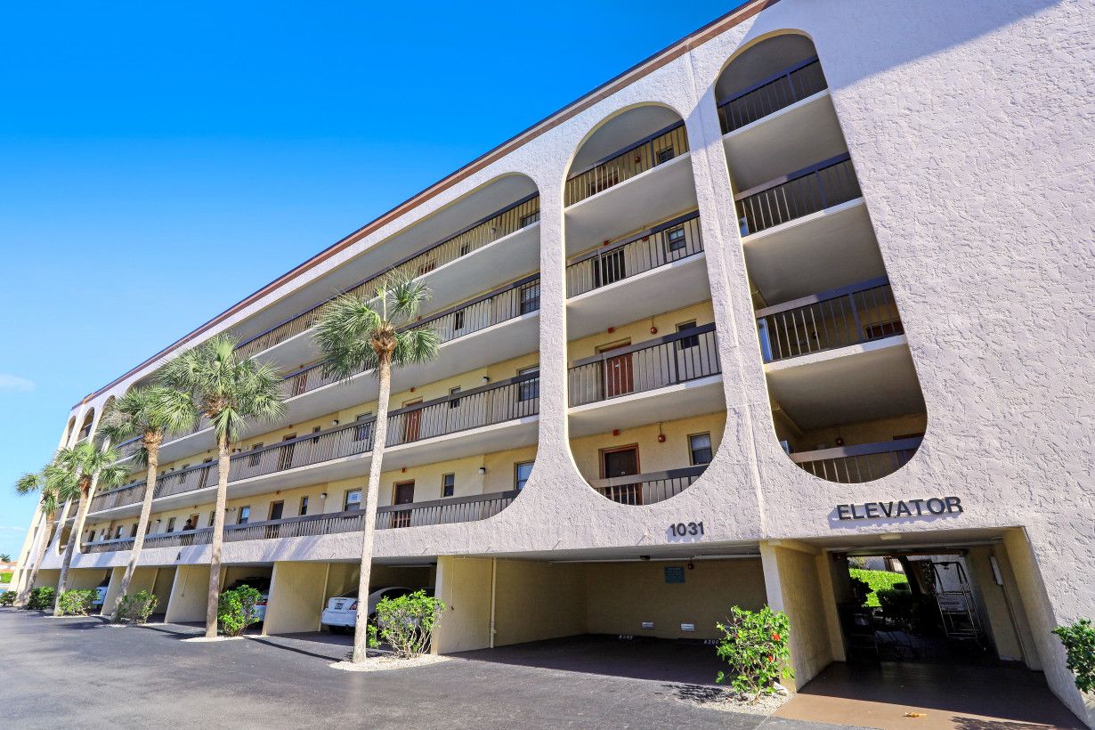 A multi-story hotel with balconies, an elevator, and a parking area.