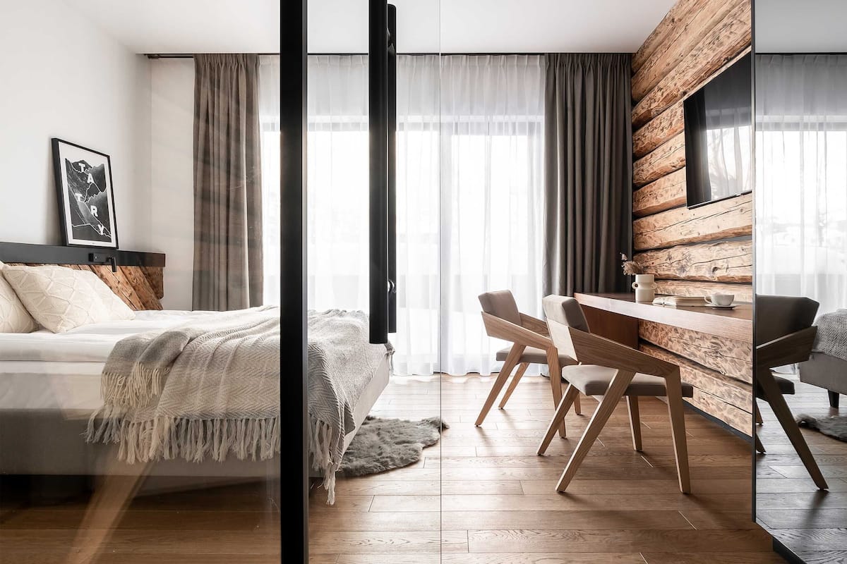 A modern bedroom with a bed, a desk, and a chair.