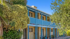 A two-story building with a balcony on the second floor, surrounded by greenery. - Chateau McNally - In the heart of Lancelin (Lancelin)