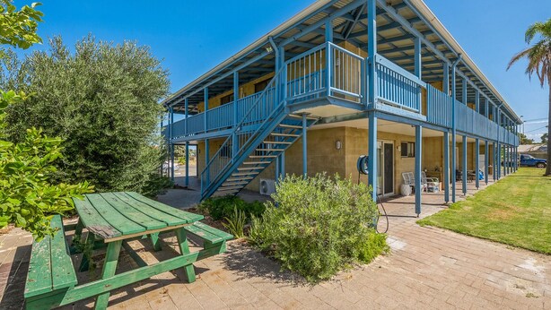A two-story building with a blue balcony and a staircase. - Chateau McNally - In the heart of Lancelin (Lancelin)