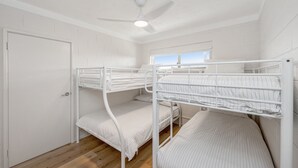 A bunk room with three bunk beds, a ceiling fan, and a window providing natural light. - Chateau McNally - In the heart of Lancelin (Lancelin)