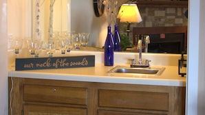 A kitchen with a wooden cabinet, a sink, and a decorative tree with lights.
