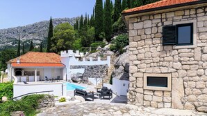 A stone building with a pool, outdoor seating, and a view of the mountains. - Duka - One Bedroom Villa, Sleeps 2 (Dubravka, Konavle)