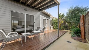 A modern house with a wooden deck, outdoor seating, and a garden area. - Anderson Central Townhouse - Walk to Shops & Beach (Torquay)