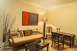 A living room with a sofa, coffee table, and dining table.