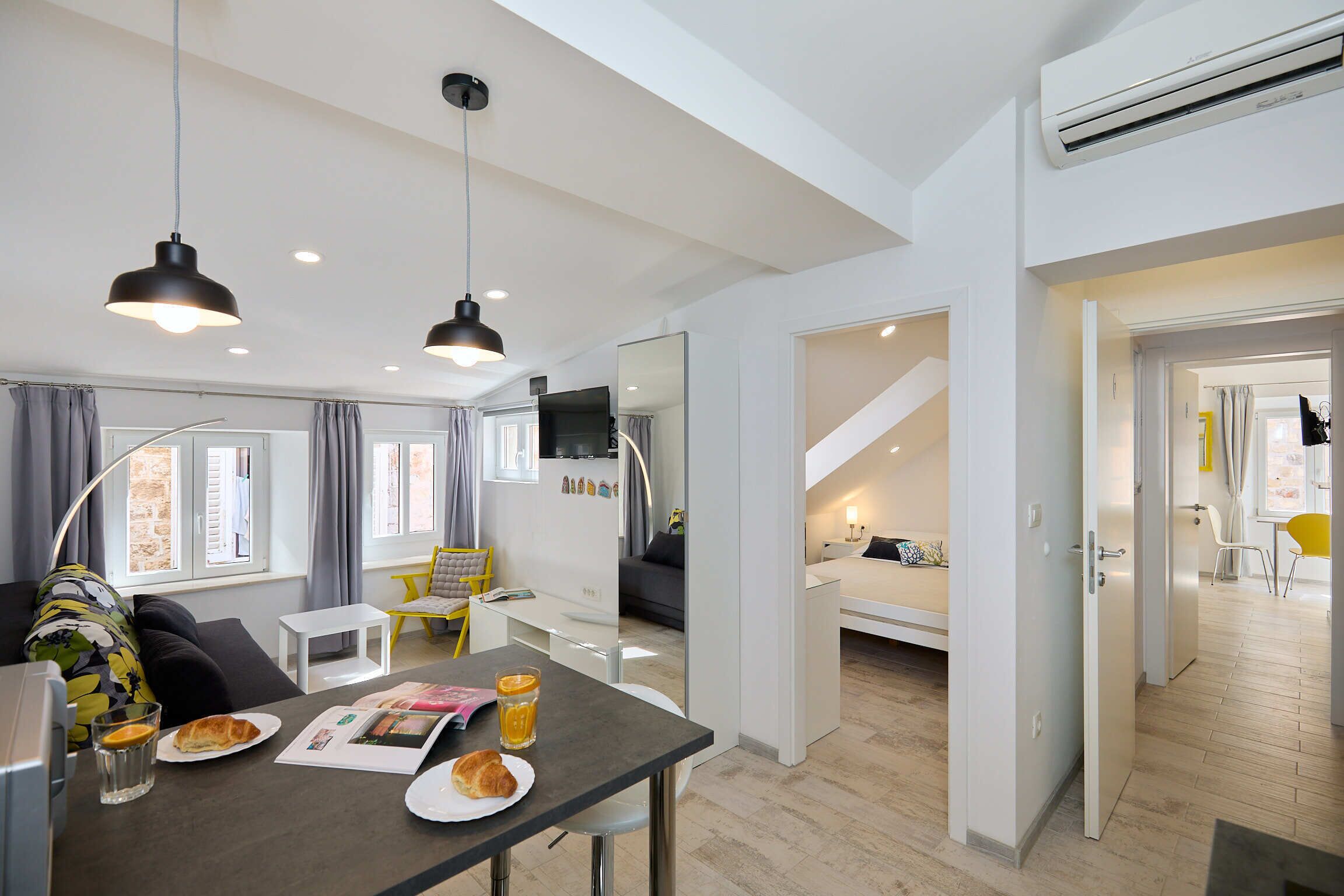 Un espacio habitable moderno y funcional, con comedor, kitchenette y un dormitorio.