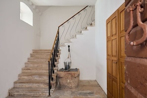 Stairs lead to a door with a metal handrail and decorative pattern.