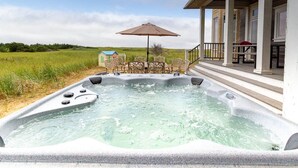 A hot tub with a patio area, outdoor furniture, and a covered seating area. - PICKLEBALL! Two hot tubs, ocean views, 2 Homes, 8 Bedrooms, RecRooms (K&KGst) (Long Beach)