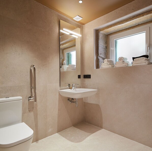 A modern bathroom with a toilet, sink, and a shower area.
