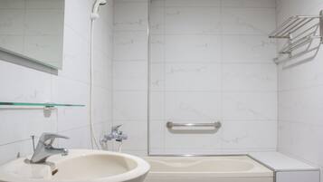 A bathroom with a sink, a bathtub, and a shower.