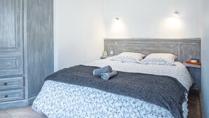 Et soveværelse med en stor seng, et garderobeskab og to væglamper.