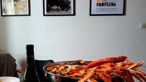 A dining table with a bottle of wine, a glass, and a seafood platter. - Beautiful renovated apartment, 5 min from the beach! (BIARRITZ)