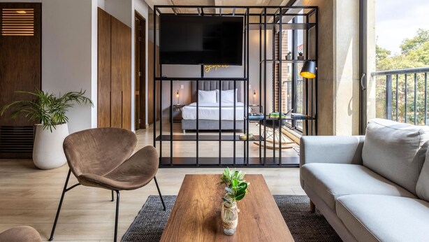 Une chambre moderne avec un grand lit, une télévision et un balcon offrant une vue agréable.