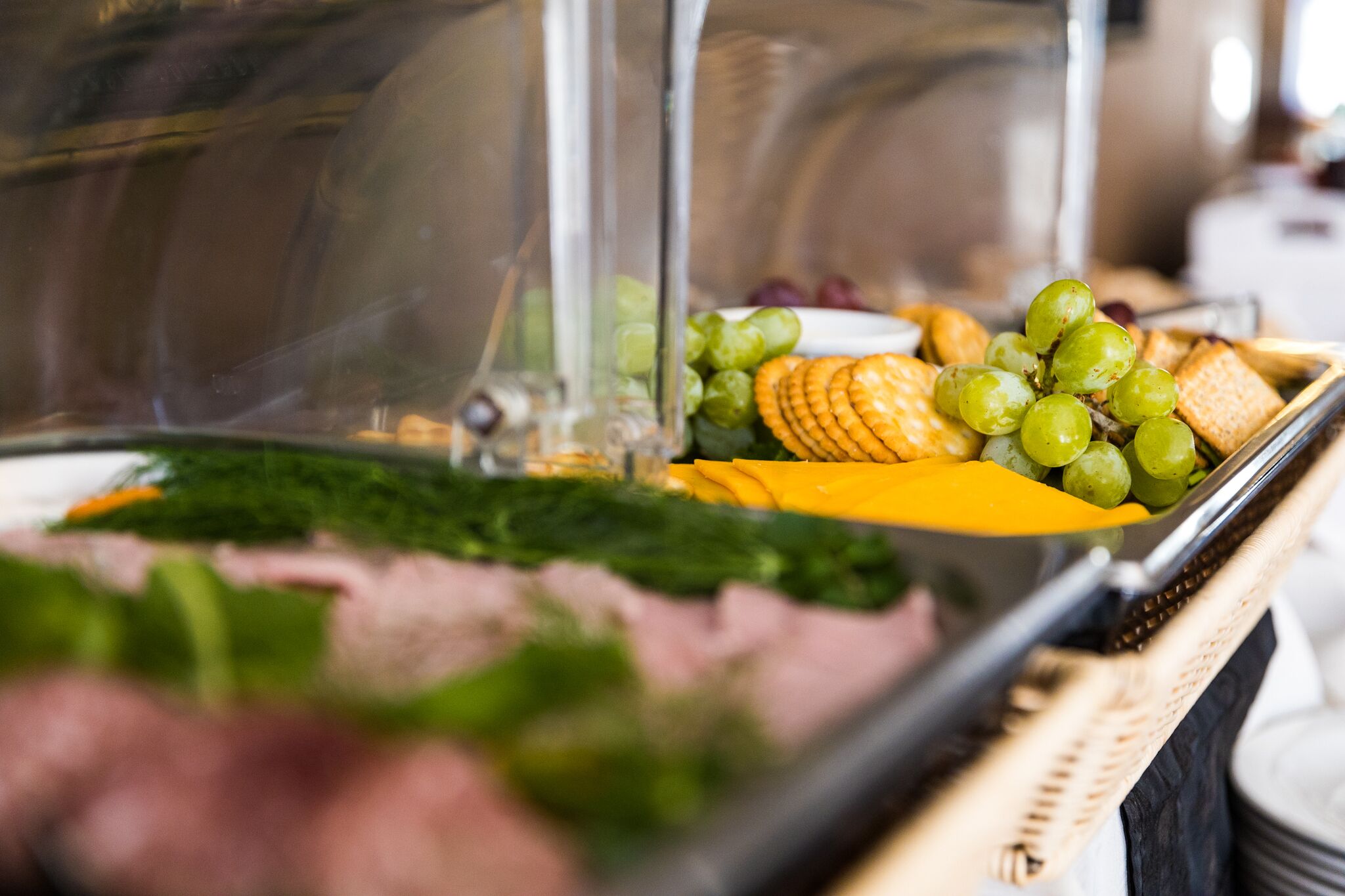 Un bufé con diversos alimentos, como queso, uvas y galletas.