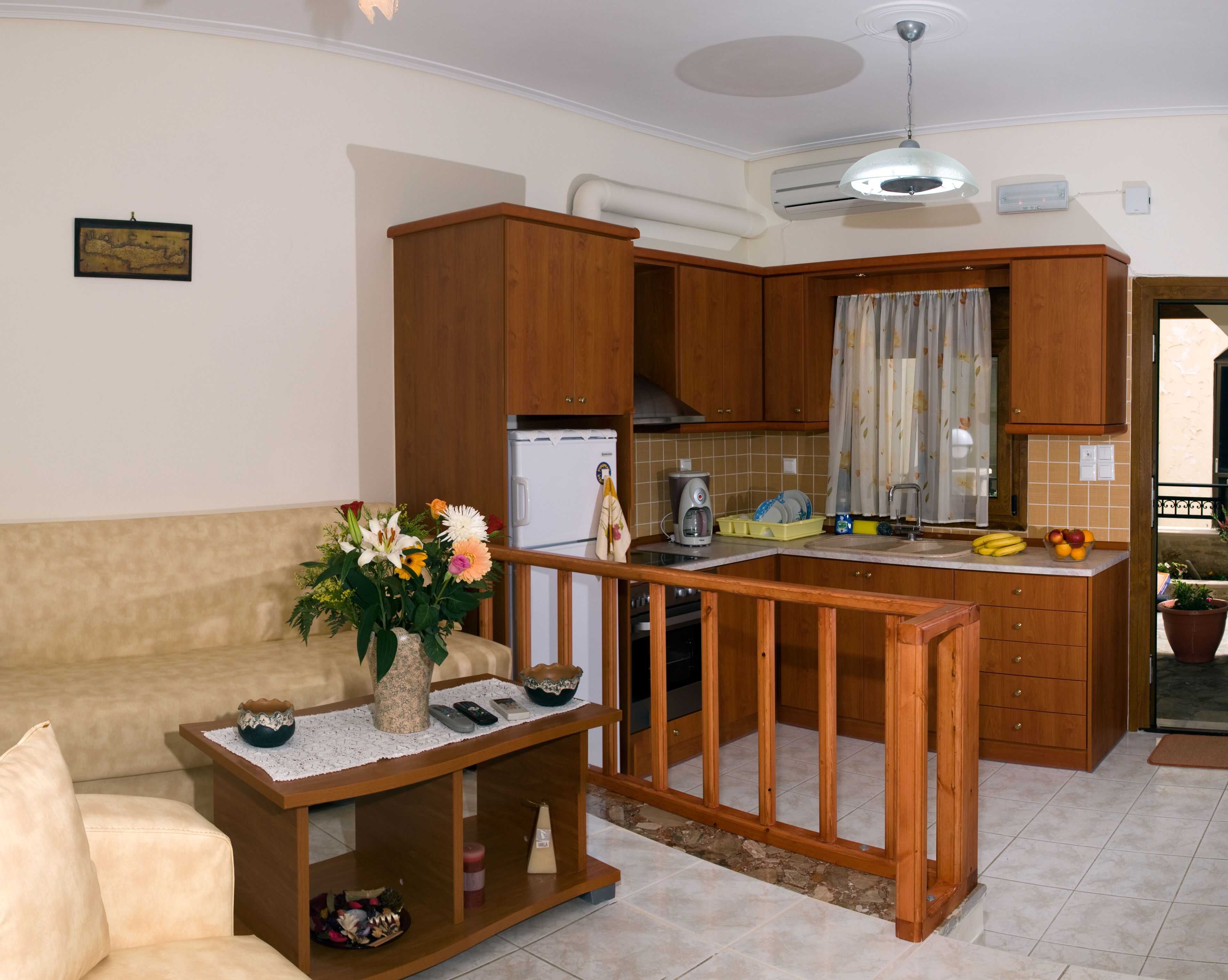A compact living space with a kitchenette, a sofa, a coffee table, and a decorative vase.