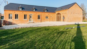 A large brick building with a sloped roof, multiple windows, and a well-maintained lawn in front. - Gîte un Air de Campagne (Gergny)