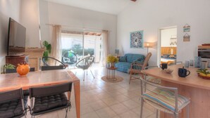 A spacious living area with a sofa, chairs, a dining table, and a kitchen area. - Kazamasavani - Belle maison proche mer ! (Cervione)