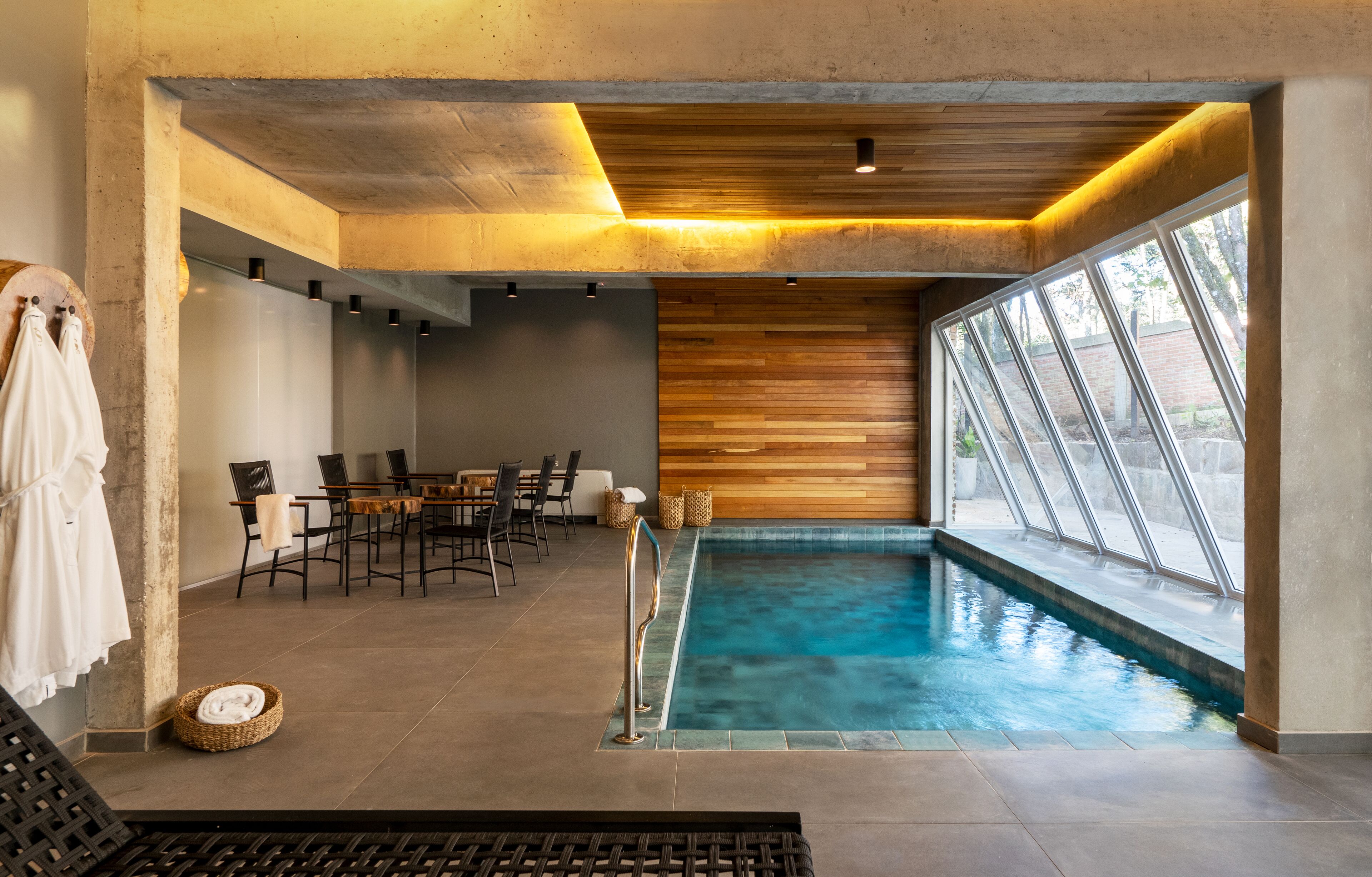 Una piscina techada, sillones reclinables de piscina