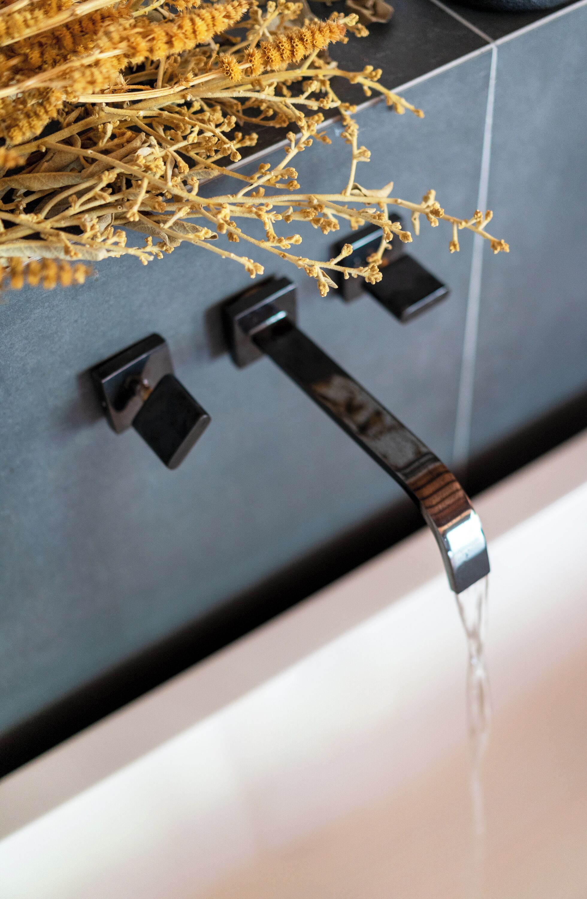 A bathroom with a faucet, a mirror, and a towel rack.