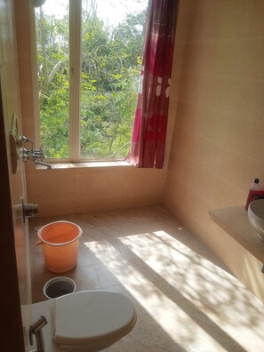 Ein kleines Badezimmer mit Toilette, Waschbecken und Fenster.