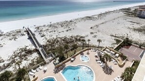 Un resort con piscina, sillas de descanso y vista a la playa y al océano.