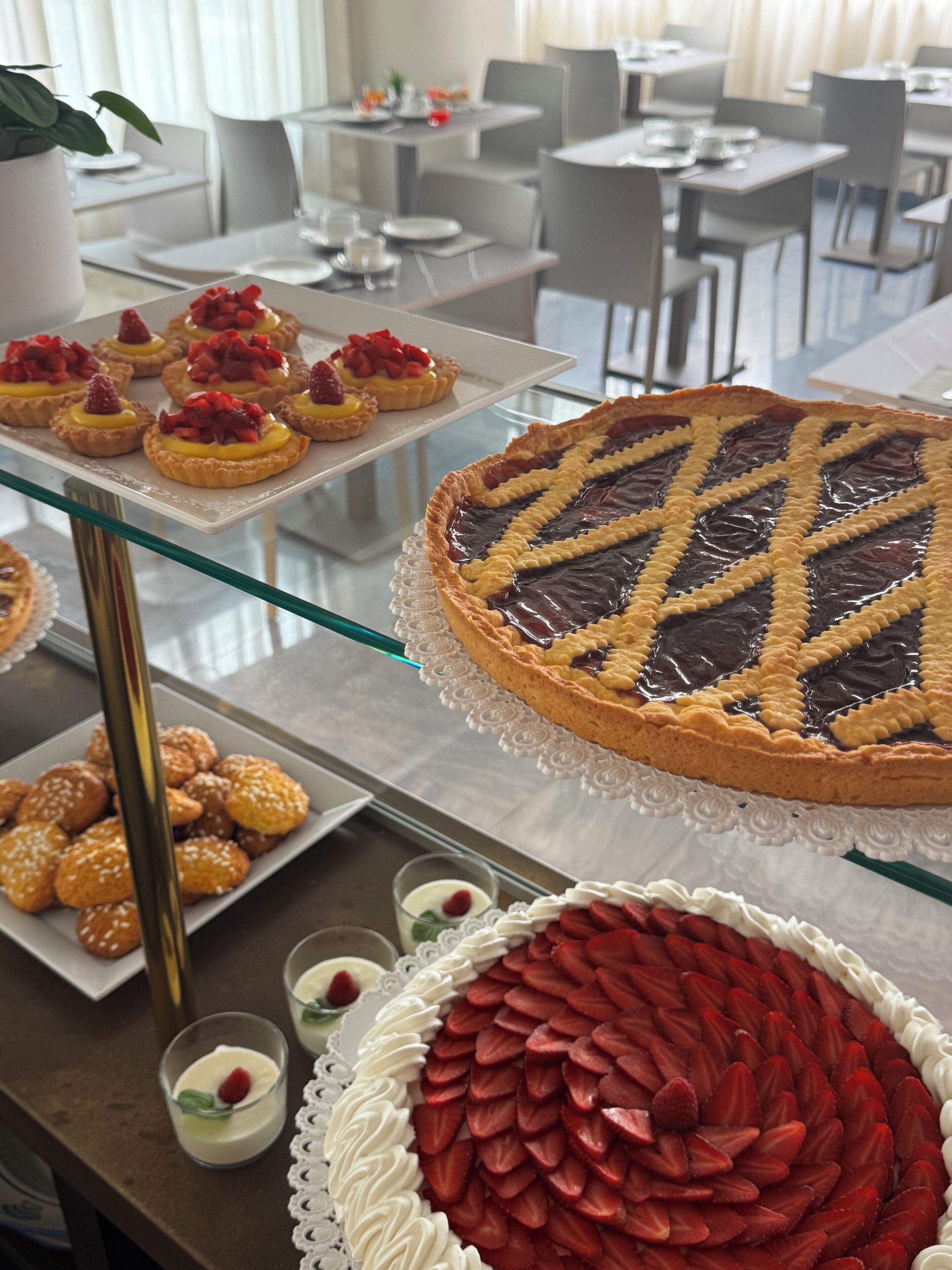 Un bufé con diversos postres, como tartas, una tarta grande y galletas.
