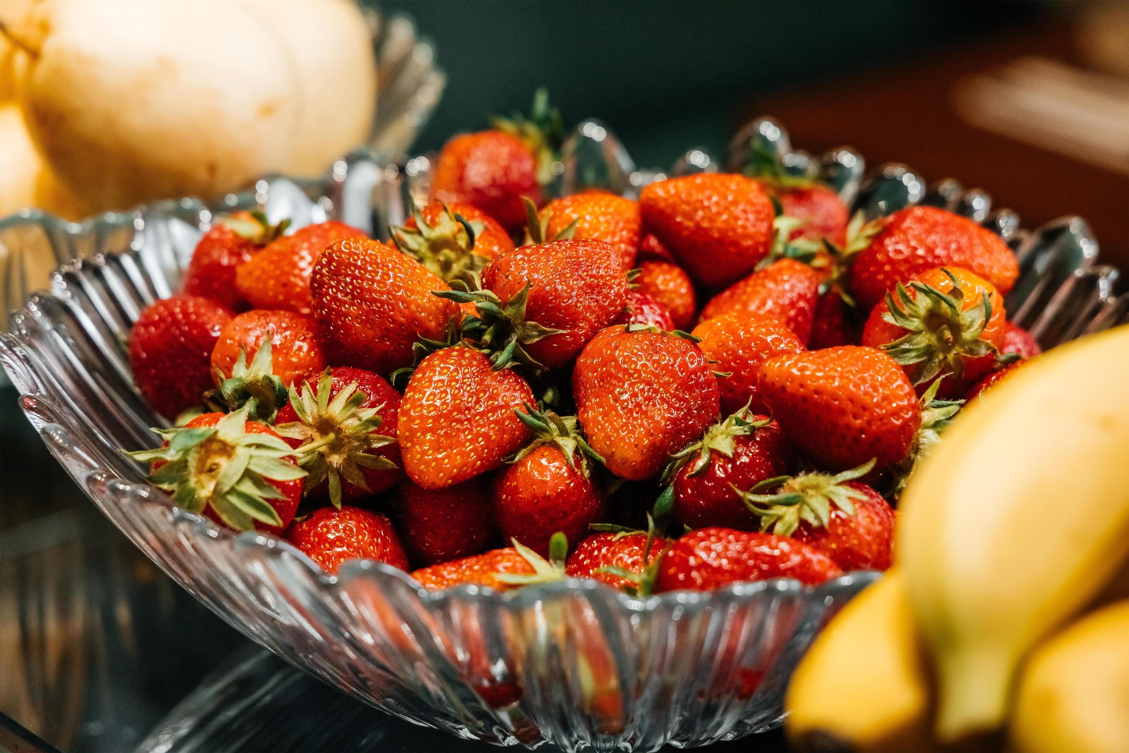 A glass bowl filled with strawberries.