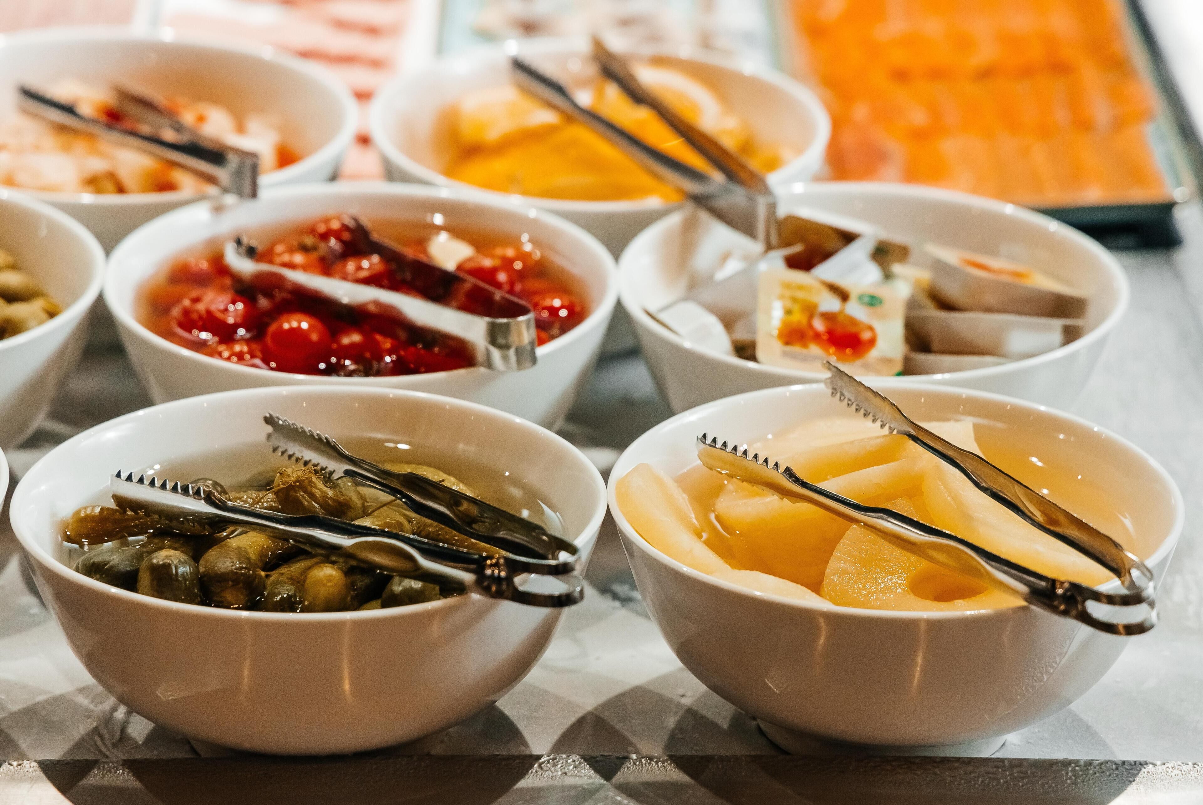 Diverse schalen met eten en bestek, op een tafel gerangschikt.