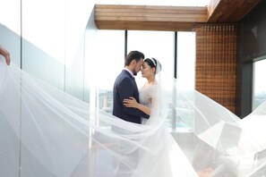 A couple embracing in a modern building with large windows and a wooden ceiling. - Panarams Tashkent Hotel, A member of Radisson Individuals (Tashkent)