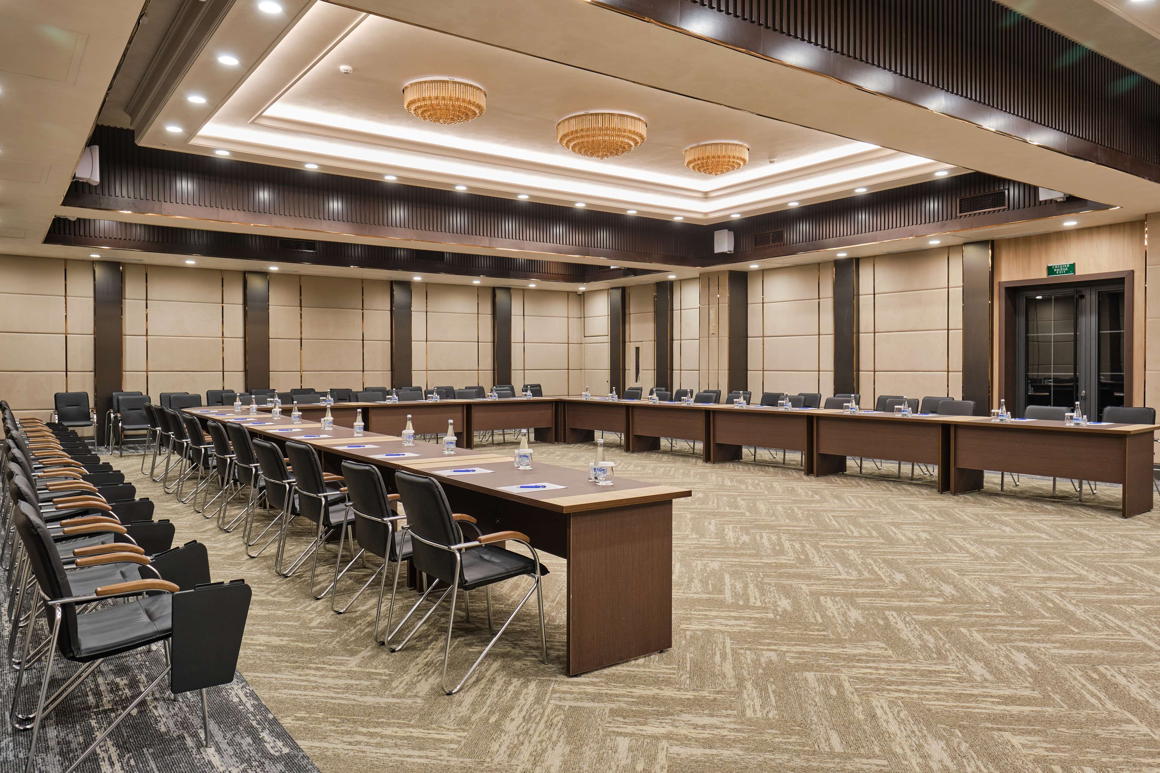 A conference room with a long table, multiple chairs, and a podium.