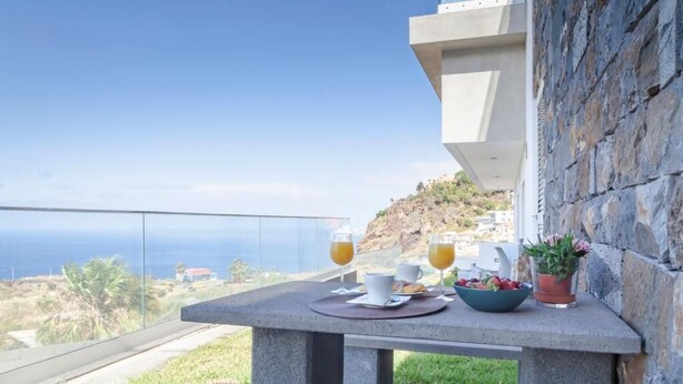 A table with breakfast items and a view of the ocean. - Infinito Azul II (Caniço)