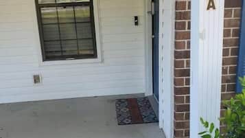 A house entrance with a door, a window, and a brick wall with the number 409A visible.