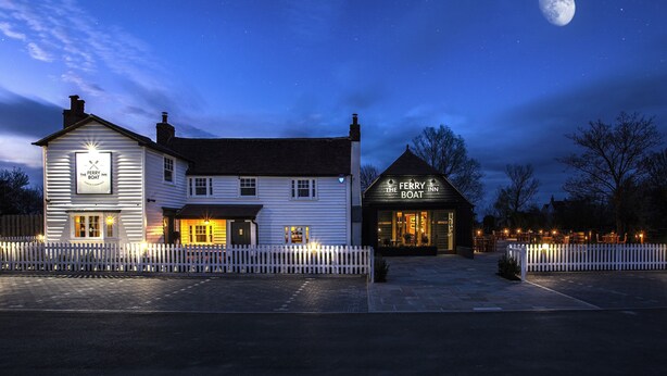 A waterfront hotel with a white facade, a black roof, and a white picket fence. - The Ferry Boat Inn (Chelmsford)