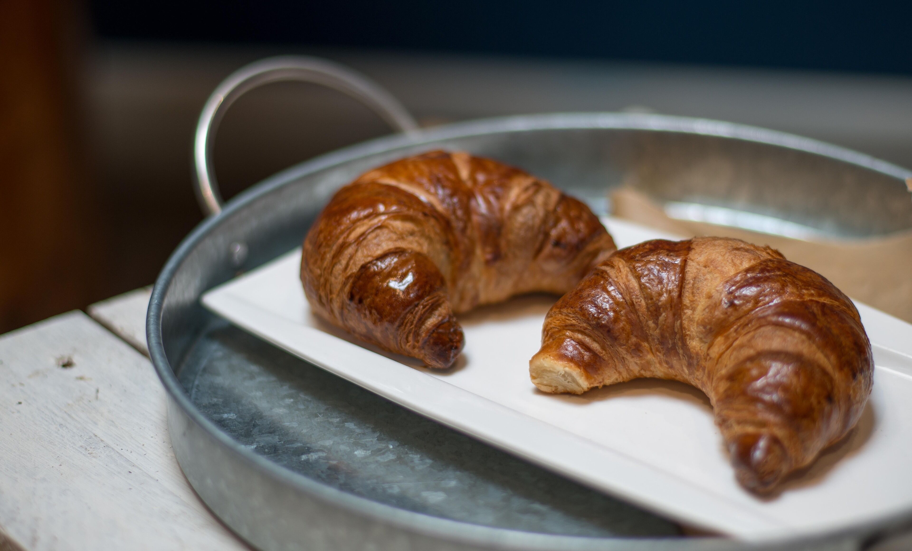 Two croissants on a white plate.