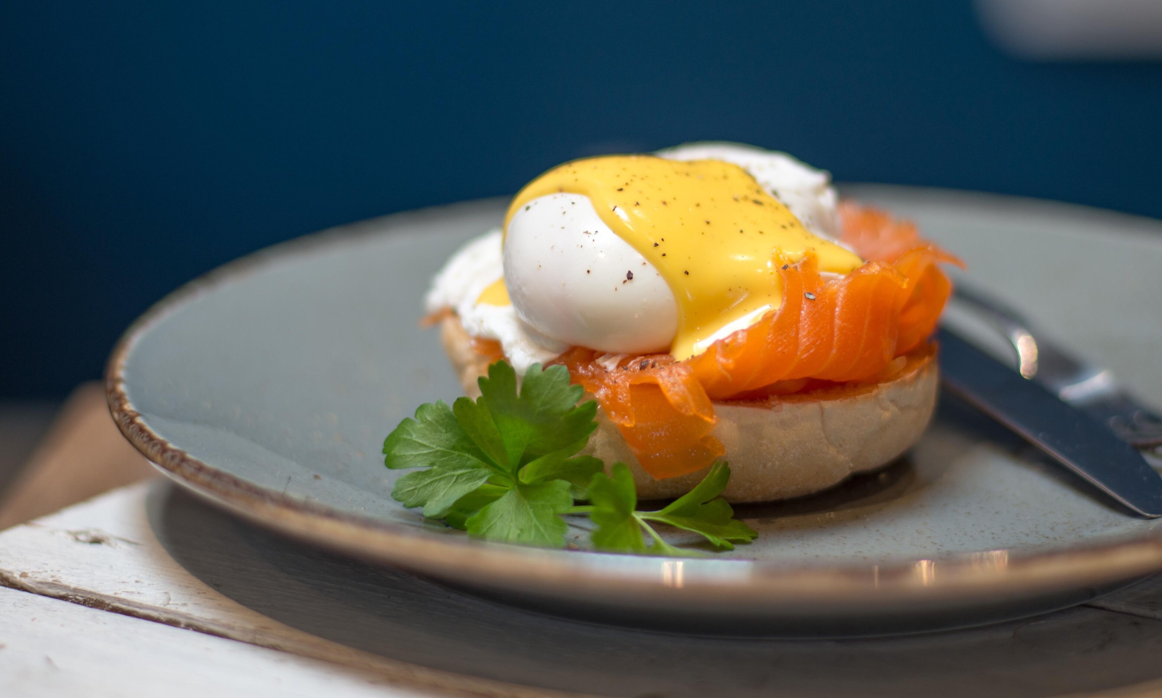 A plate with a sandwich, a boiled egg, and a garnish.