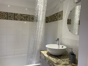 Bathtub, hair dryer, towels, toilet paper