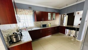 Una cocina con armarios de madera oscura, salpicadero de azulejos y pileta de acero inoxidable.