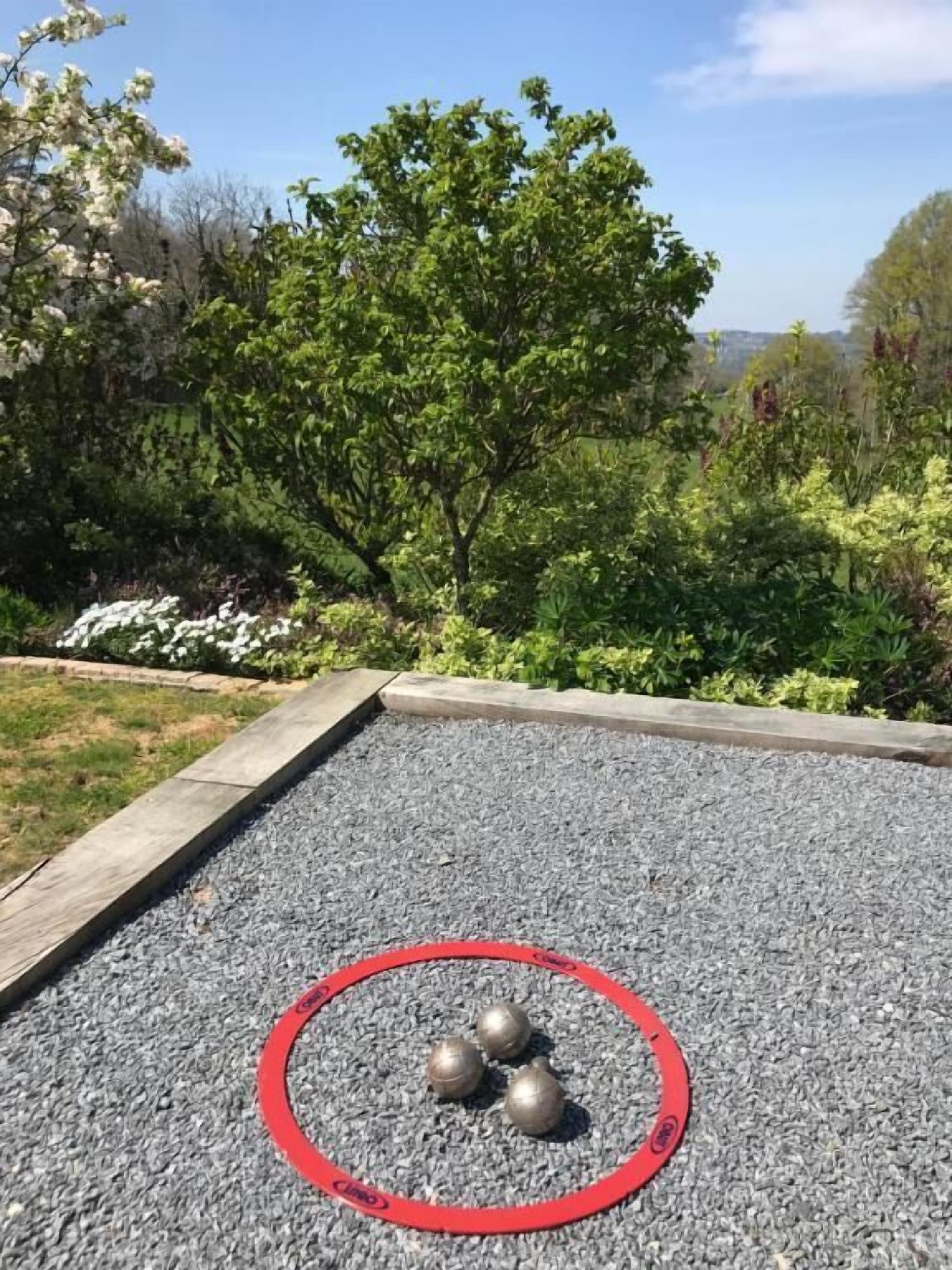 A garden with a gravel area and a red circular boundary.