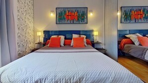 A hotel room with a large bed, two bedside tables, a nightstand, and a wall-mounted artwork. - Escale En Correze (Sadroc)