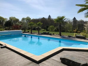 Una piscina al aire libre de temporada, sombrillas, tumbonas