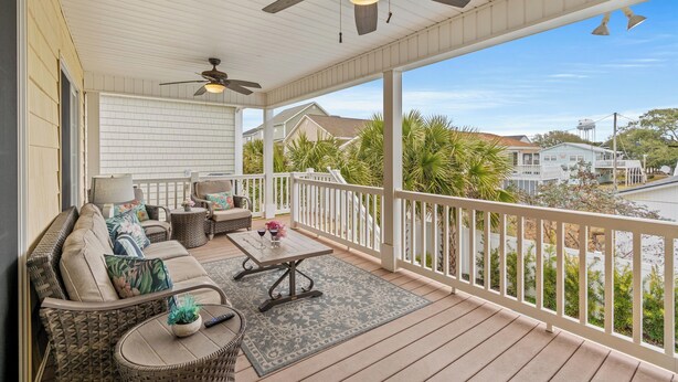 A covered porch with a ceiling fan, outdoor furniture, and a view of the neighborhood. - No Shoes, No Shirt, No Problems at this 4 Bed/3 Bath Home with Hot Tub - Walk to Beach (North Myrtle Beach)