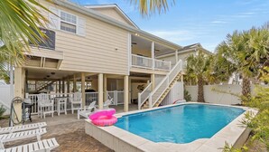 A two-story house with a swimming pool, outdoor seating, and a covered patio. - No Shoes, No Shirt, No Problems at this 4 Bed/3 Bath Home with Hot Tub - Walk to Beach (North Myrtle Beach)