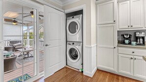 A laundry room with a washer and dryer, a coffee maker, and a small seating area with a table and chairs. - No Shoes, No Shirt, No Problems at this 4 Bed/3 Bath Home with Hot Tub - Walk to Beach (North Myrtle Beach)